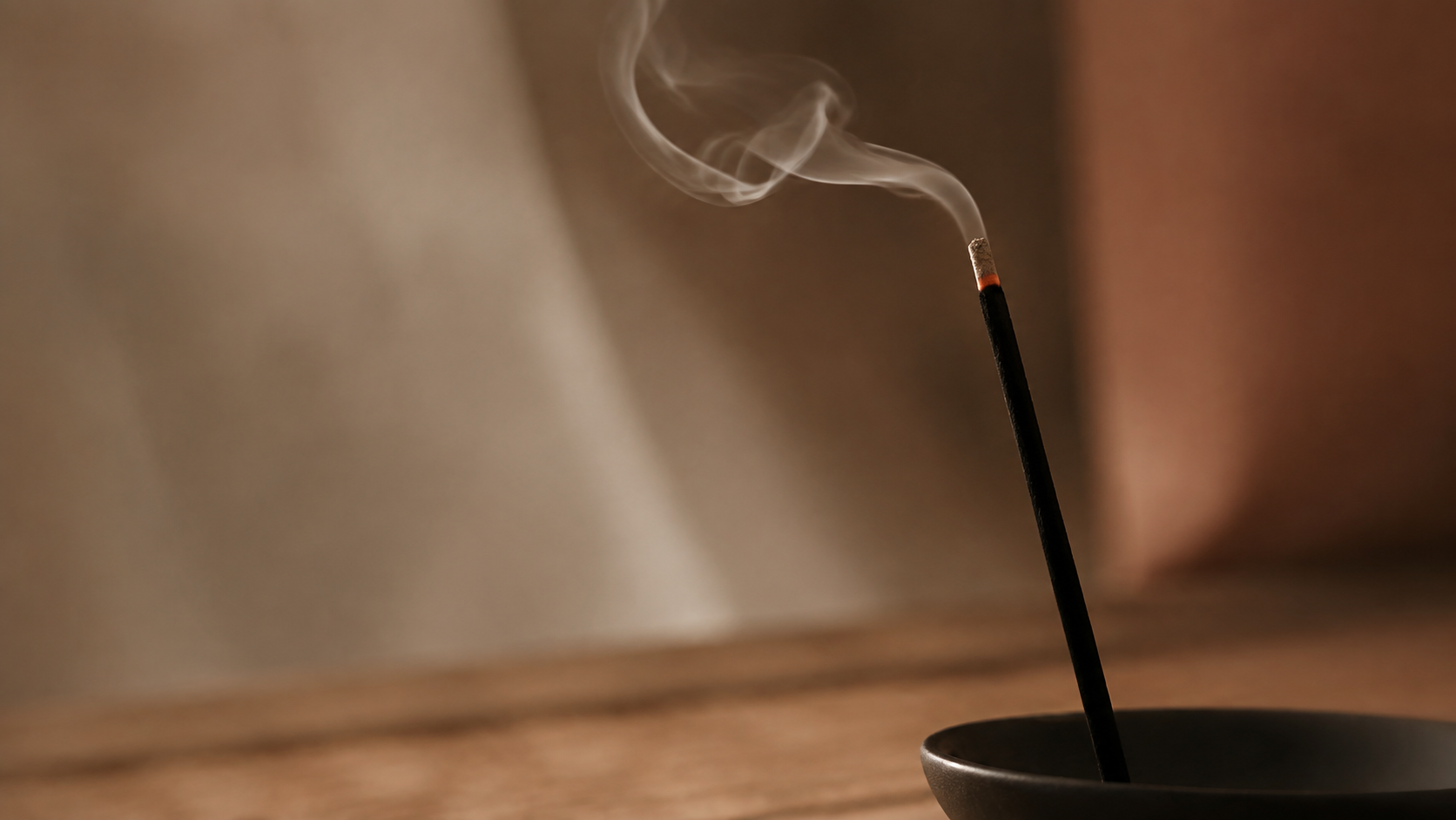 A glowing incense stick creating a warm, atmospheric mood